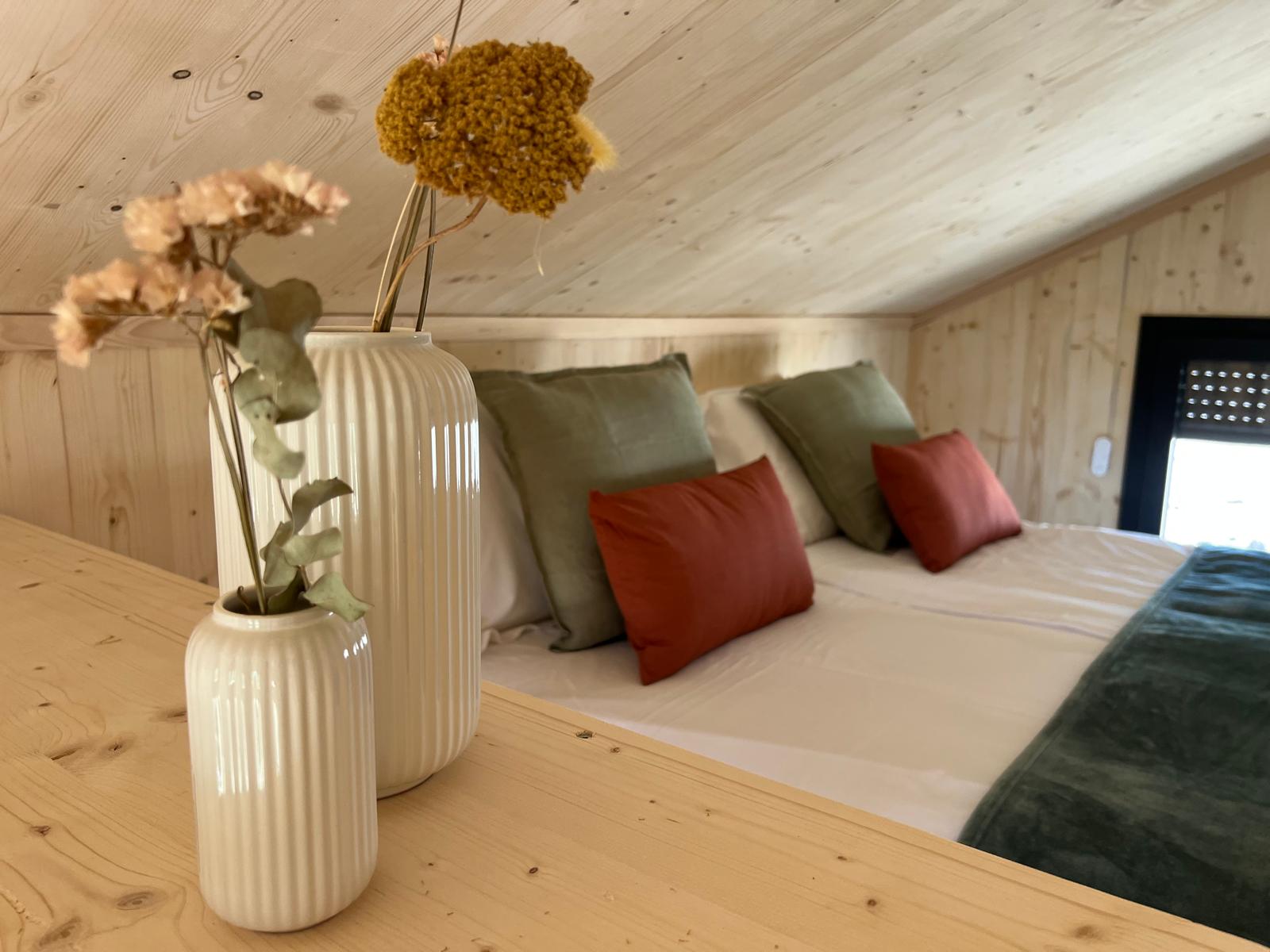 Chambre en mezzanine du COQhome avec coussins lin et déco naturelle