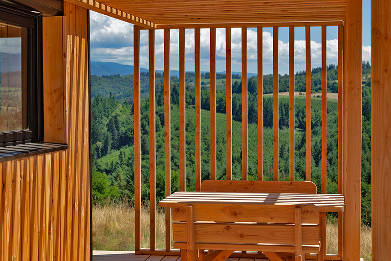 Terrasse claustra bois du COQhome, vue panoramique sur les collines boisées
